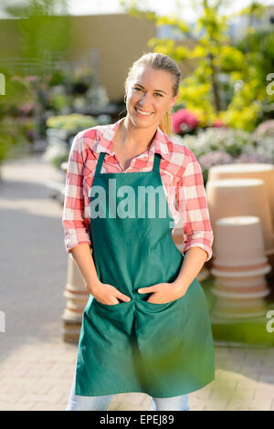 Garden center woman worker posing in apron Stock Photo