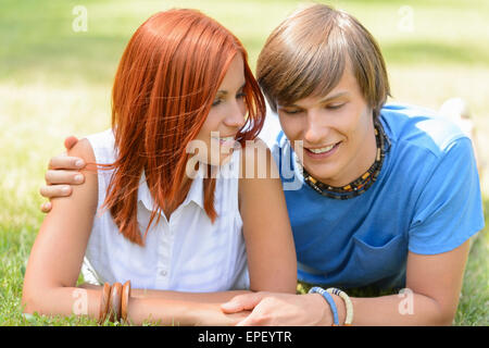 Teenage boyfriend and girlfriend lying on grass Stock Photo