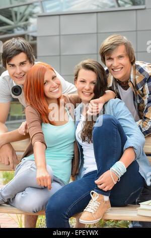 Cheerful friends hanging out by college campus Stock Photo