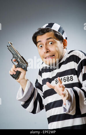 Prisoner with gun against dark background Stock Photo