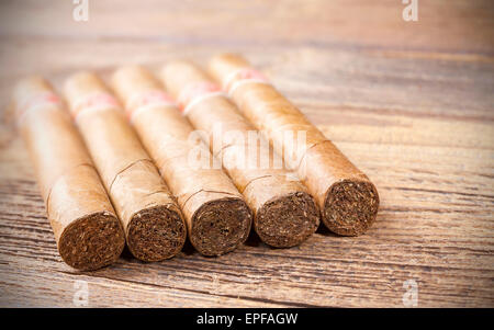 Close up picture of cigars on a wooden table, shallow depth of field. Stock Photo