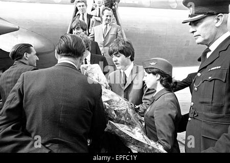 The Beatles in Liverpool for the Premier of a Hard Day's Night. Paul McCartney is presented with flowers as he walks down the stairs of the plane into a Liverpool airport. 10th July 1964.