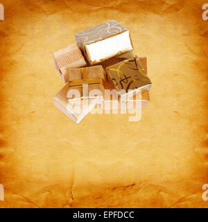 Gift box in gold wrapping paper on vintage cardboard background Stock Photo