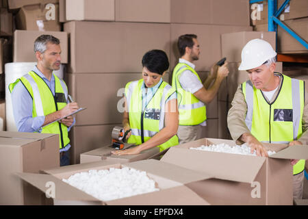 Warehouse workers in yellow vests preparing a shipment Stock Photo