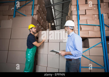 Warehouse worker loading up a pallet with manager Stock Photo