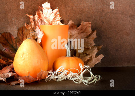 Pile of pumpkins with autumn foliage on abstract background Stock Photo