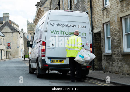 A Waitrose home delivery worker van driver bringing a shopping order to a customer in Cirencester, Gloucestershire, England UK Stock Photo