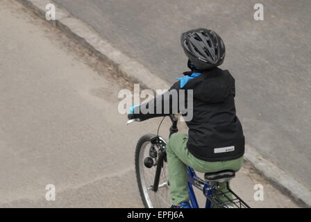 Child riding a bike in a city street. Stock Photo