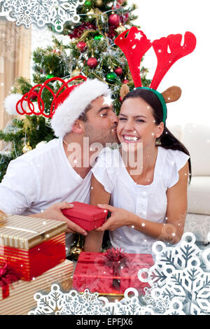 Composite image of smiling couple giving presents for christmas Stock Photo