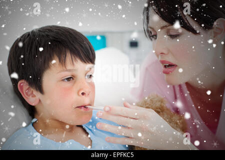 Composite image of caring nurse taking her patients temperature Stock Photo