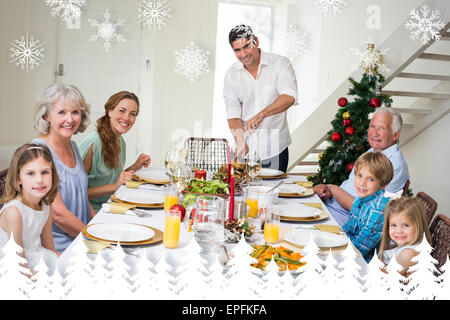 Composite image of family having christmas meal at dining table Stock Photo