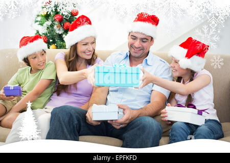 Composite image of family exchanging christmas gifts Stock Photo