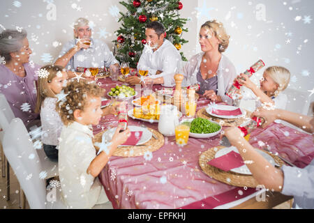 Composite image of family having christmas dinner Stock Photo