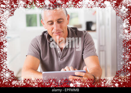 Composite image of happy man using tablet Stock Photo