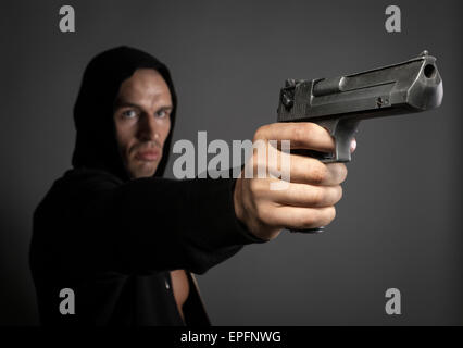 man shooting gun isolated on gray background Stock Photo