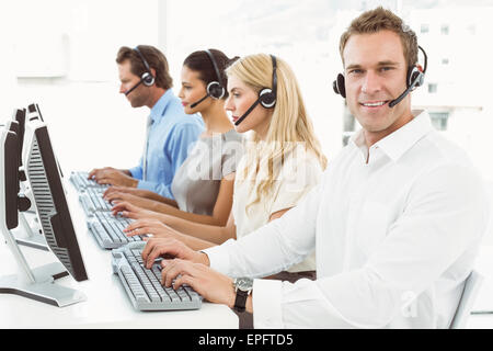 Business people with headsets using computers in office Stock Photo