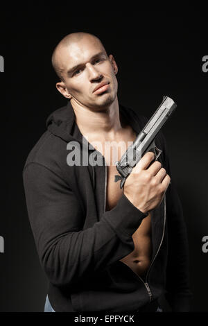 male gangster holding a gun isolated on black Stock Photo