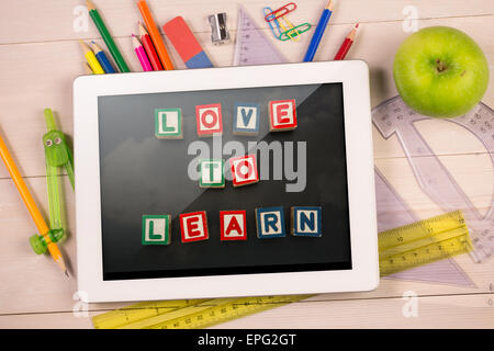 Composite image of digital tablet on students desk Stock Photo