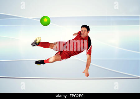 Composite image of football player in red kicking Stock Photo