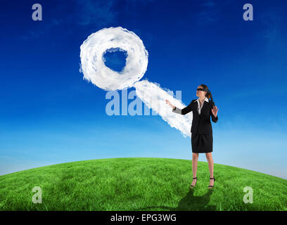 Composite image of blindfolded businesswoman with hands out Stock Photo