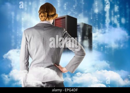Composite image of redhead businesswoman with hand on hip Stock Photo