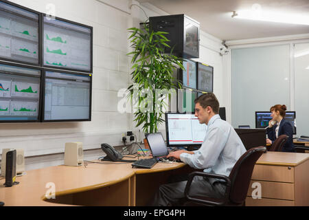 Technicians sitting in office running diagnostics Stock Photo
