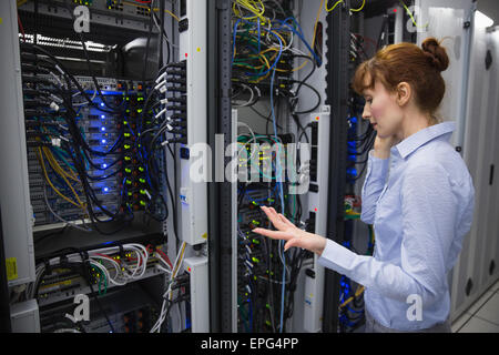 Technician talking on phone while analysing server Stock Photo