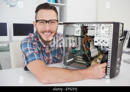 Computer engineer working on broken console smiling at camera Stock Photo