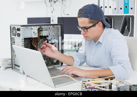Computer engineer working on broken console with laptop Stock Photo