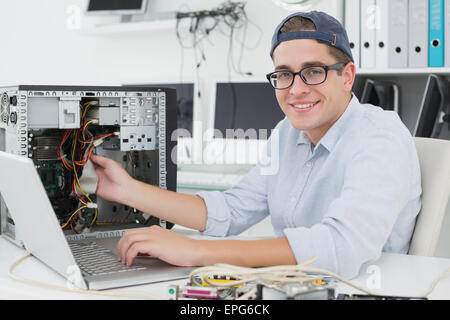Computer engineer working on broken console with laptop Stock Photo