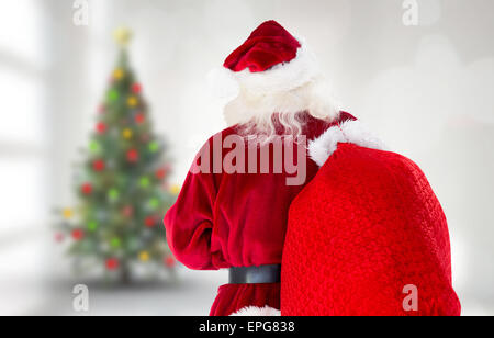 Composite image of santa claus carrying sack Stock Photo