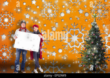 Composite image of couple holding a large sign Stock Photo