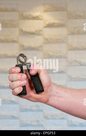 Man with hand grip exerciser Stock Photo