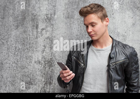 Casual young guy using smart phone Stock Photo