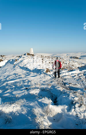 Walker in snow admiring view of Shutlinsloe & Cheshire from The Roaches, Peak National Park, Staffordshire, England. Stock Photo