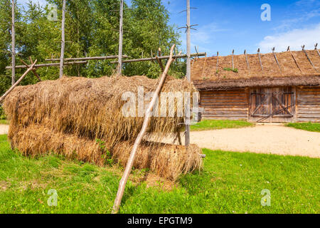 Russian wooden rural architecture example, outdoor hay drying construction near old barn with locked gate Stock Photo