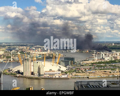London, UK. 18th May, 2015. View over the O2 Building showing black smoke rising from a Warehouse Fire in Lombard Wall, Charlton, London. Over 70 firefighters are tackling this large blaze. Credit:  David Horn/Alamy Live News Stock Photo