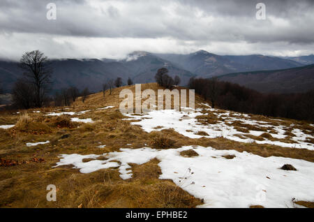 Stormy mountains with snow peaks on distance Stock Photo
