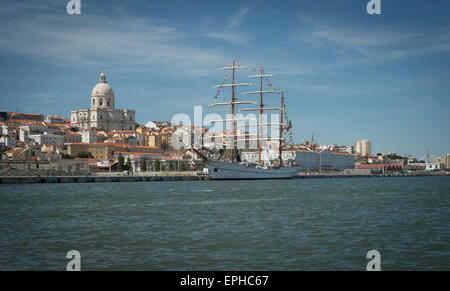 view of the city of Lisbon from the River Tagus with a tall Ship moored on the dock. Stock Photo