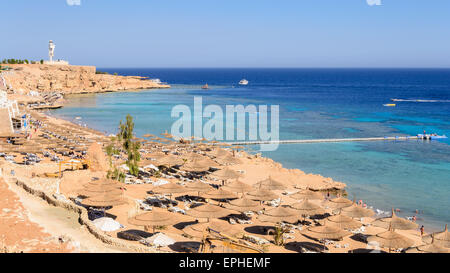 In the picture a typical Egyptian beach in the Red Sea with wood and straw umbrellas and turquoise sea. Stock Photo
