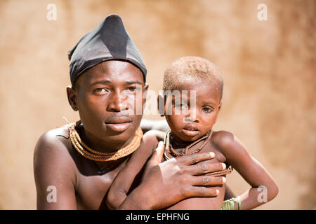 Africa, Namibia. Himba Tribe Village. Close up of man holding child. Stock Photo