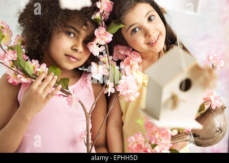 Two cute girls with beautiful pink flowers Stock Photo