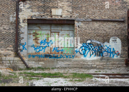 Old warehouse wall with graffiti. Stock Photo