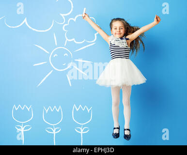 Pretty girl making chalk drawings on the wall Stock Photo