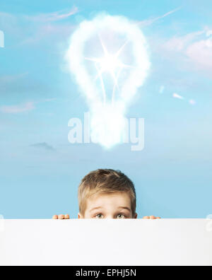 Little boy with a light bulb above head Stock Photo