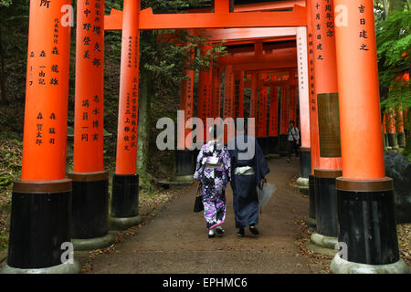 Japanese Geisha and partner at Fushimi Inari Shrine gardens  in Kyoto. Stock Photo