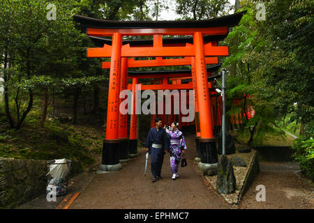 Japanese Geisha and partner at Fushimi Inari Shrine gardens  in Kyoto. Stock Photo