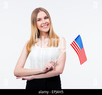 Happy young businesswoman holding US flag over gray background and looking at camera Stock Photo