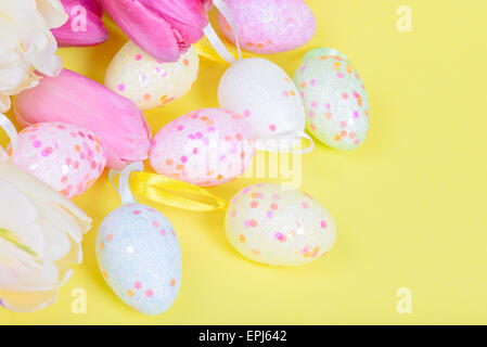 Multicolored Easter eggs with tulips flowers on a light blue background ...