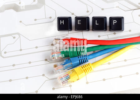 IT HELP, Assistance - HELP made of keyboard keys with colourful network cables on white circuit board background Stock Photo